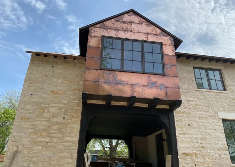 Copper metal panel facade on a stone building for Skylight Installation in Northwood