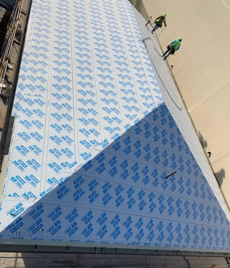 Professional roofers installing underlayment on a metal roof in Northwood